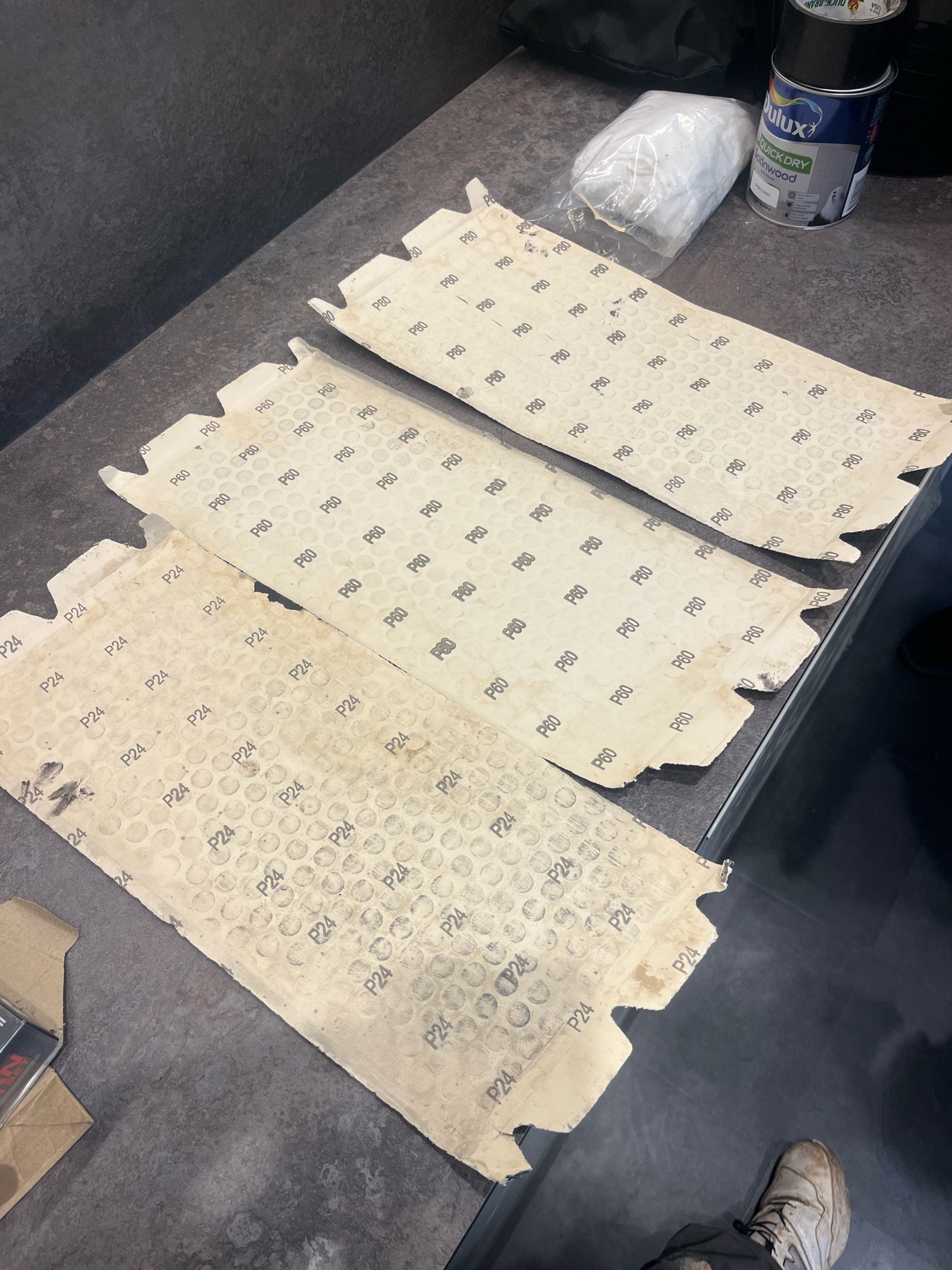 Backs of three used sanding sheets marked P24, P60 and P80.