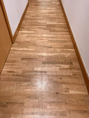 Worn oak floors in Fish Islands, Stratford, London, showing scratches, scuffs, and faded finish before sanding.