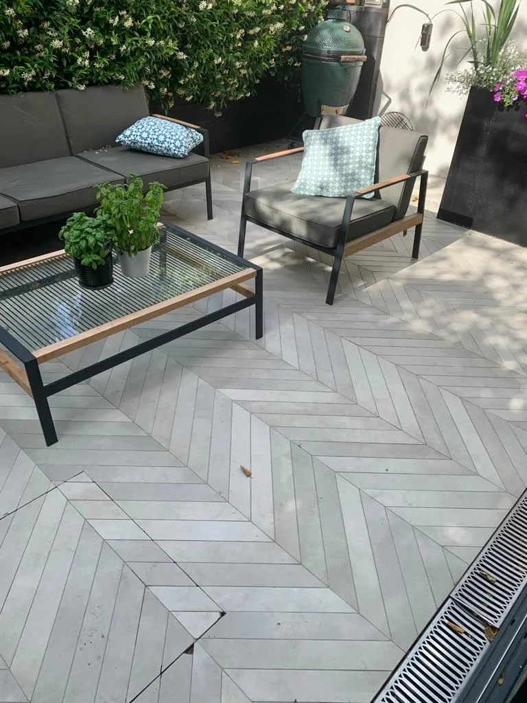 Porcelain patio flooring in Royal Oak, London, showing pre-cleaning condition with visible dirt and debris.