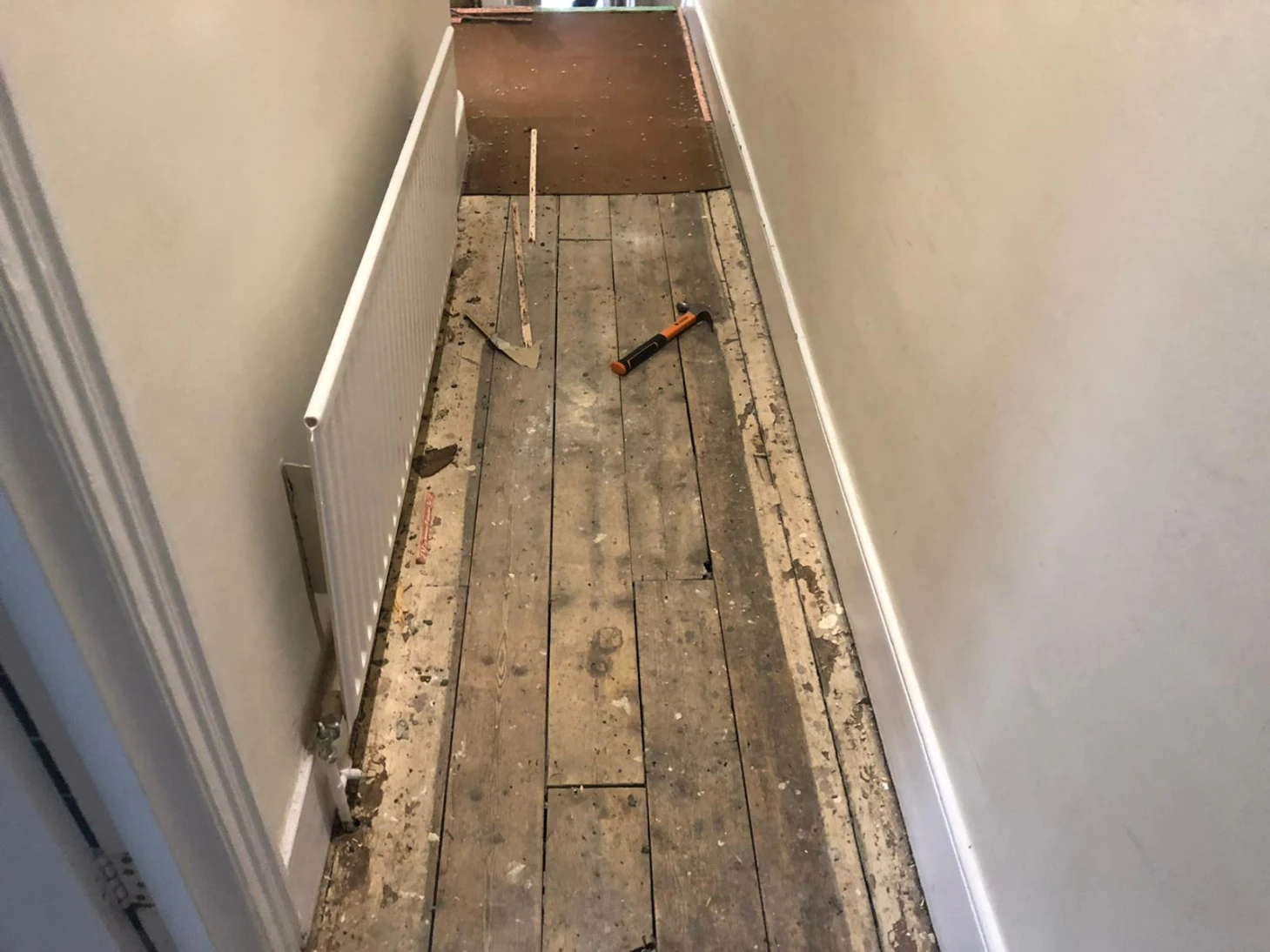 Damaged pine floorboards in a London hallway