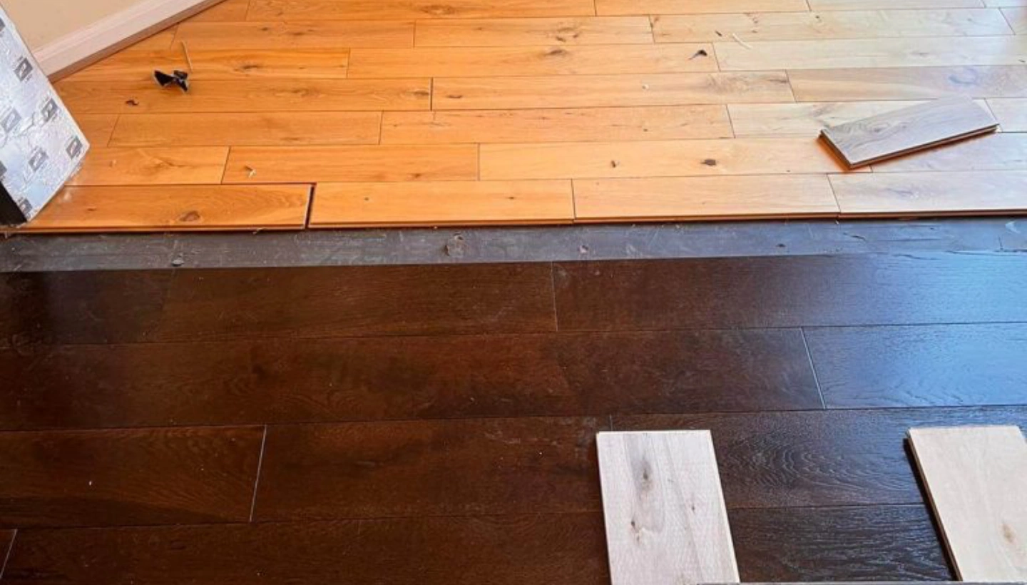 Close-up of wood floor fitting assessment in St Johns Wood, London, showing the transition between the old and new flooring.