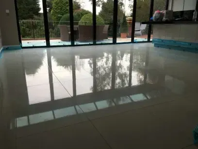 Glossy tiled floor reflecting sliding glass doors and garden patio.