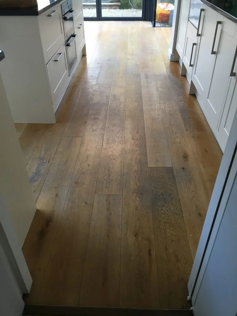Worn oak kitchen floor in Dulwich Village showing heavy foot traffic wear before professional sanding and restoration.