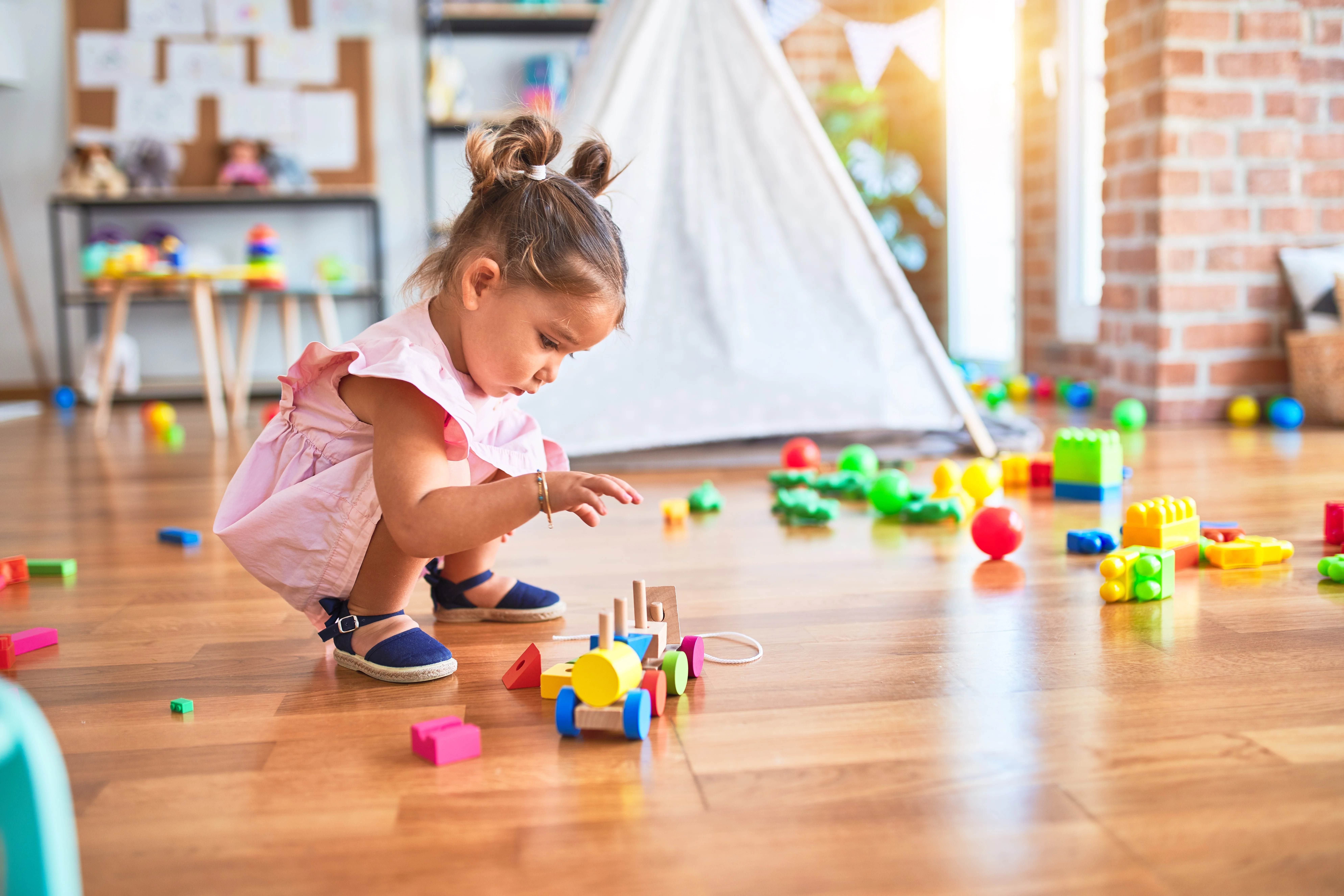 Child playing on a clean, polished wood floor in a family home, demonstrating the benefits of professional floor restoration services in London.