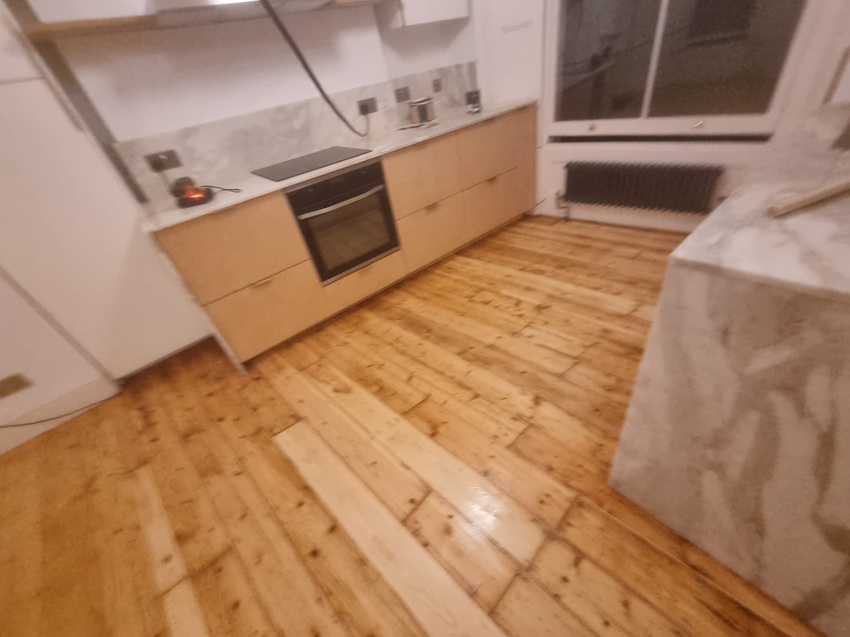 Restored pine floorboards in London kitchen after sanding and refinishing