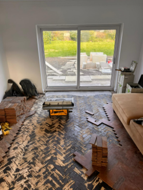 Teak herringbone floor repair process in progress with lifted planks in a Berkhamsted home