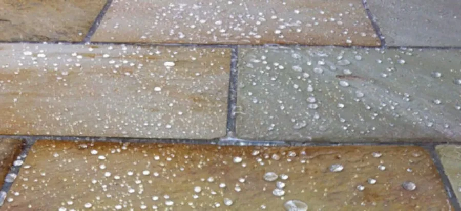Water beading on a sealed natural stone patio in London, demonstrating effective stone sealing