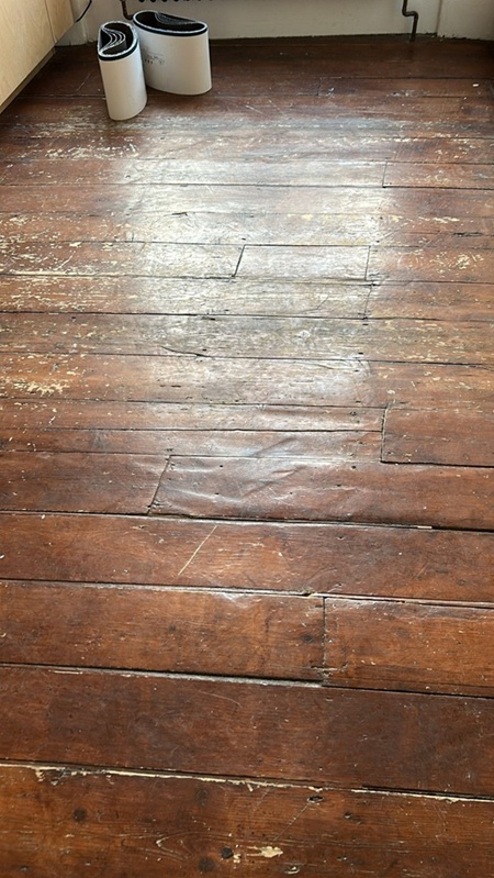 Close up of worn Victorian pine floorboards before restoration in London home