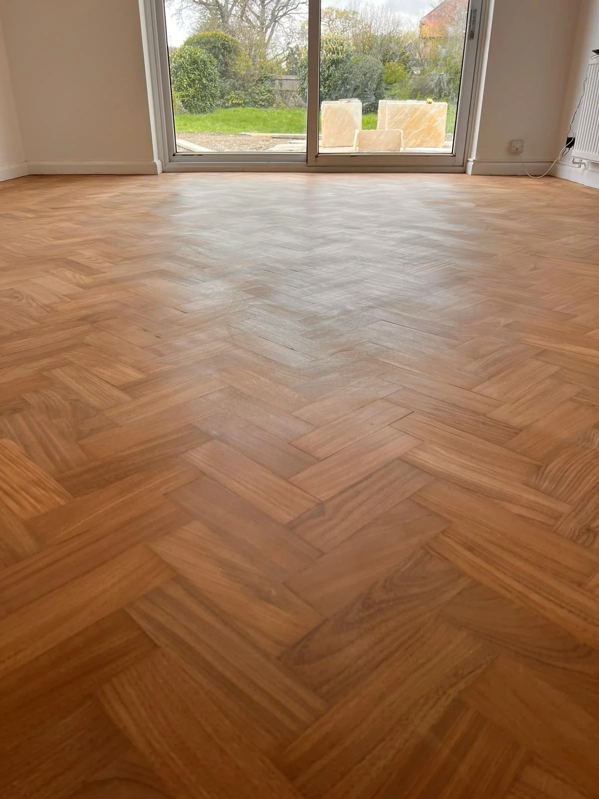 Restored teak herringbone floor after repairs and sanding in a Berkhamsted home