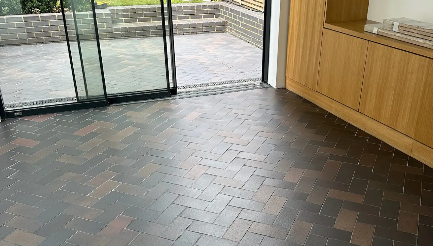 Clean, satin-finish blue ceramic tile floor in herringbone layout after restoration