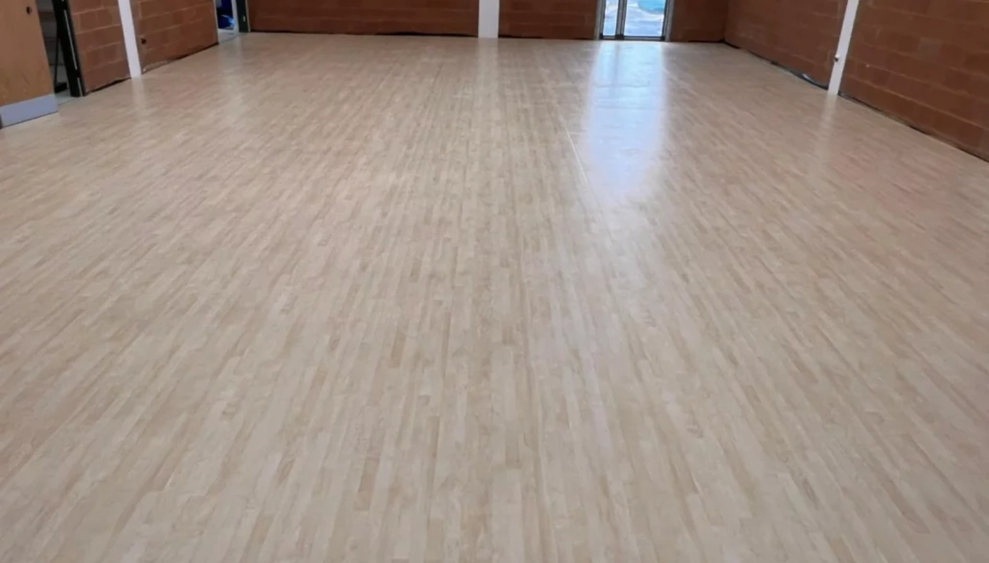 Newly installed sports hall floor before professional finishing, deep cleaning, and sealing for durability and slip resistance.