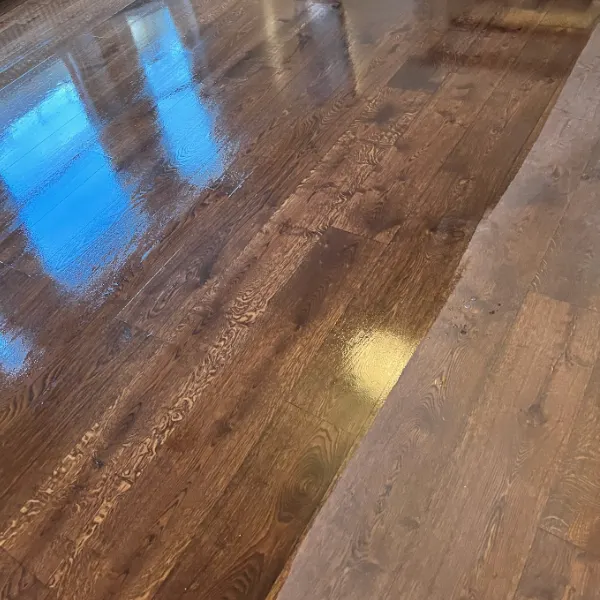 Moderately worn wooden floor in London, half buffed and recoated to show restored shine and protection against dullness and minor wear.
