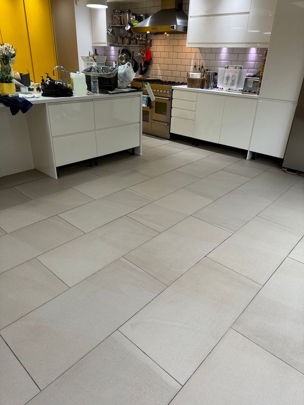 Open-plan London kitchen with grey ceramic floor tiles after professional tile floor cleaning.