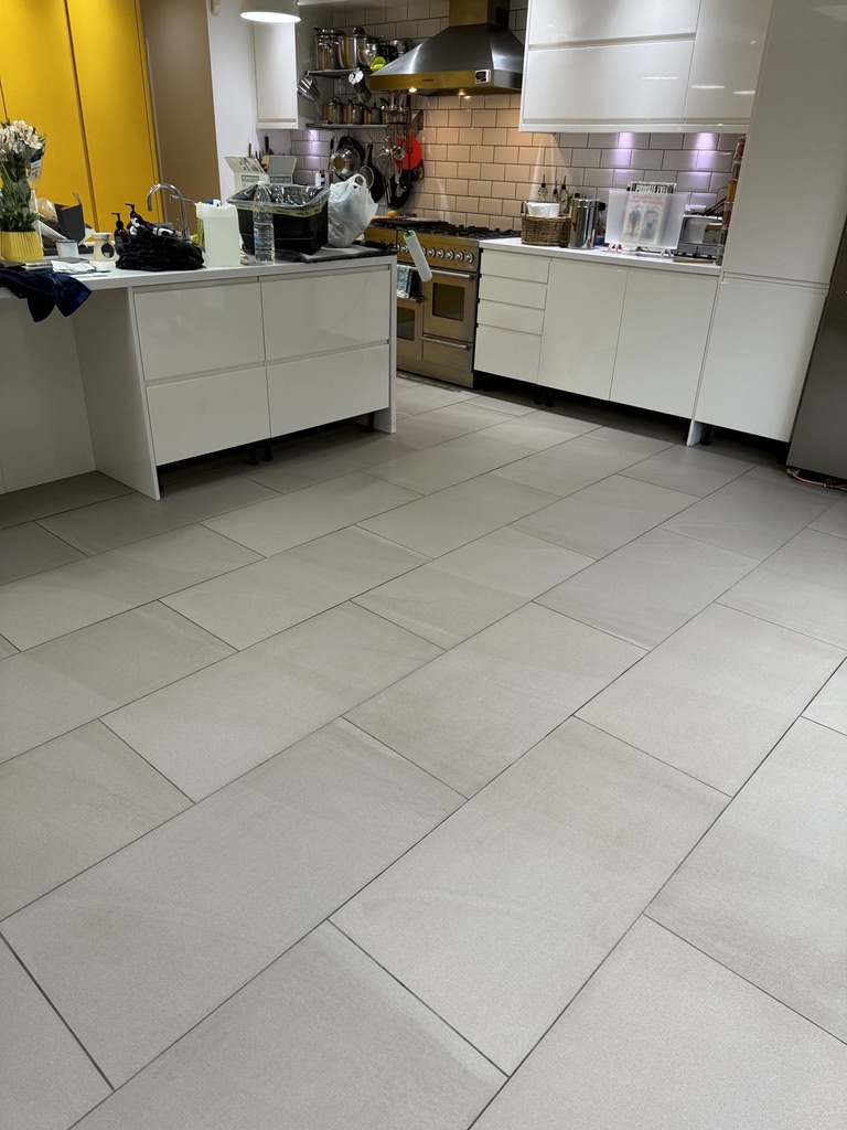 Open-plan London kitchen with grey ceramic floor tiles after professional tile floor cleaning.