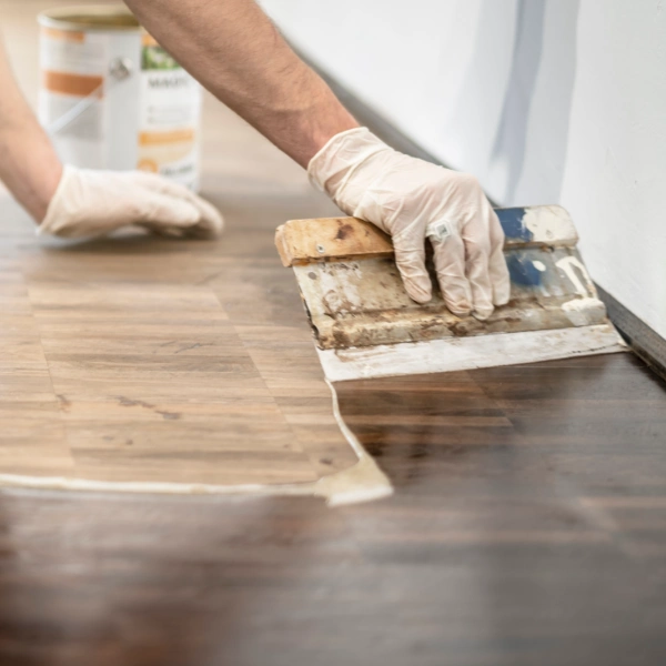 Professional applying a sealing coat to a wooden floor in London with precision tools.