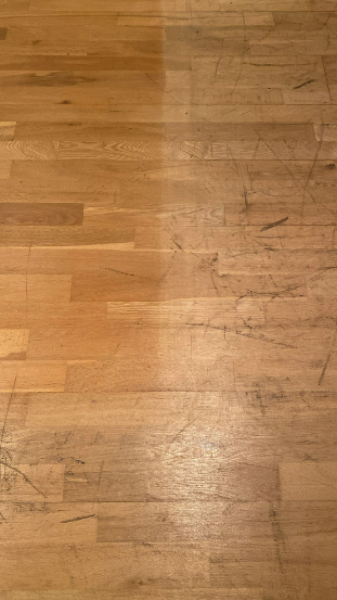 Close-up of worn oak flooring before sanding in Fish Islands, Stratford, London, showing scratches, scuffs, and uneven surface.