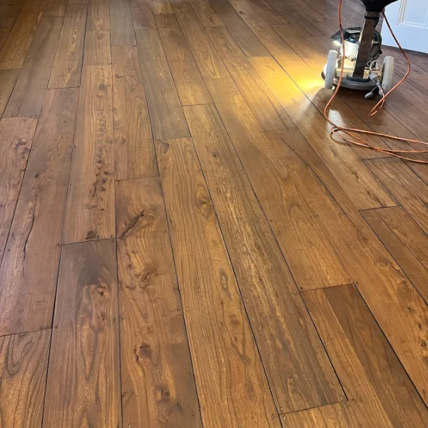 Restored wood floor in Islington with a sanding machine and protective setup, highlighting professional aftercare and support