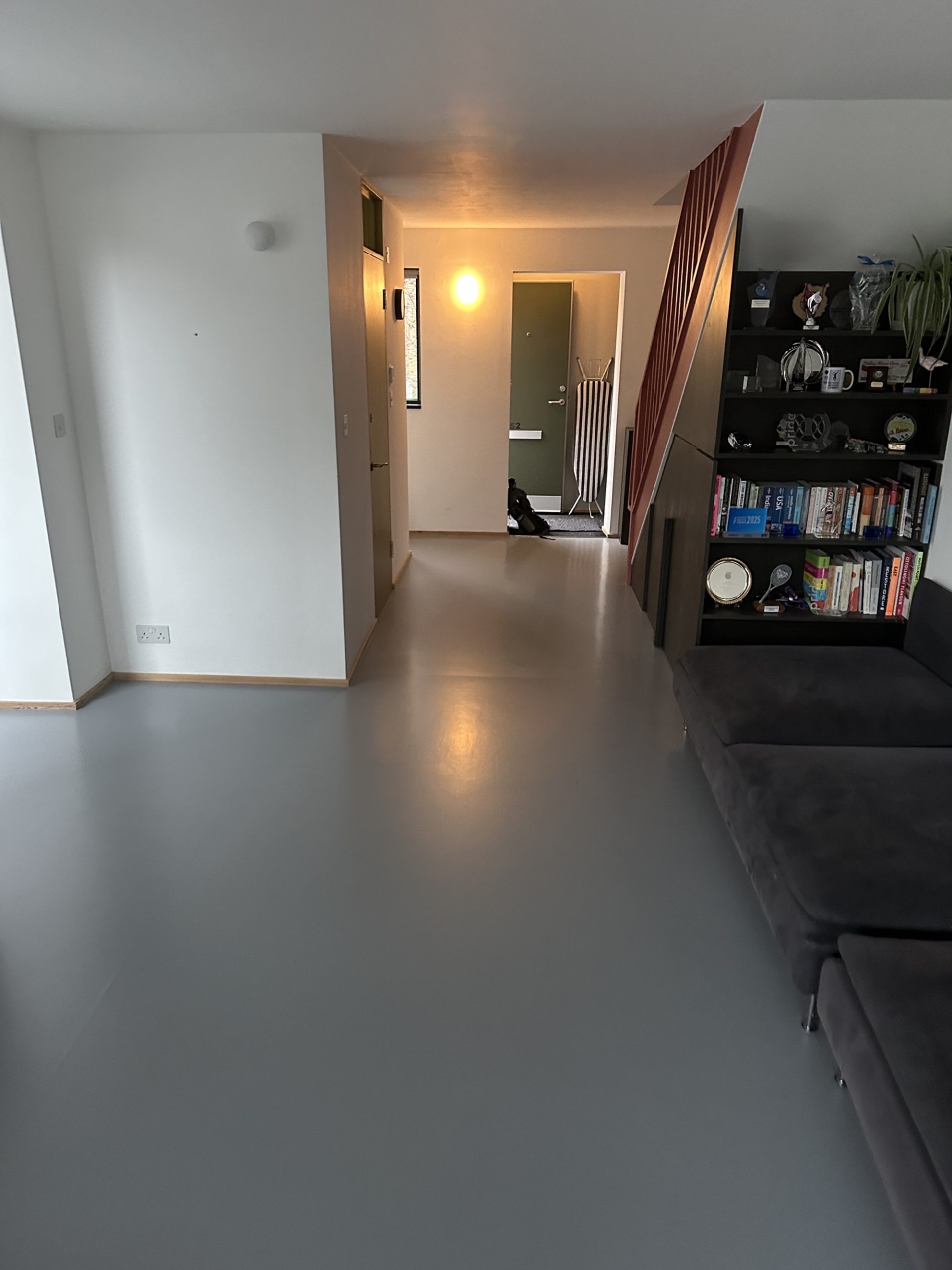 Grey resin floor finish in living space and hallway in Kennington, South London