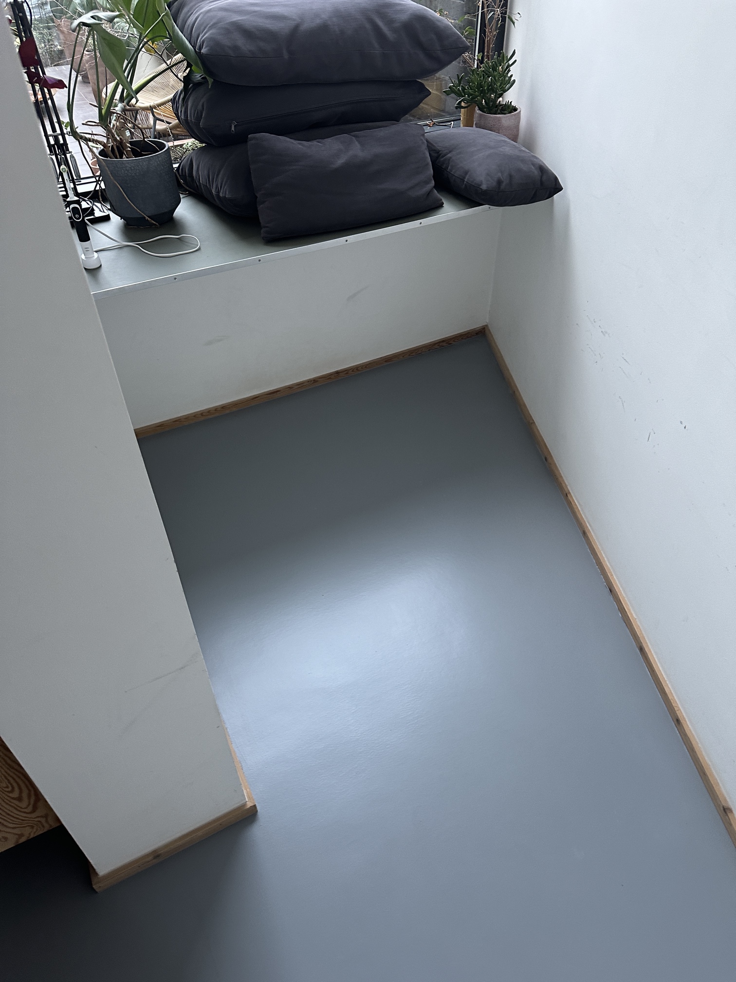 Finished grey resin floor in a small room alcove in Kennington, South London