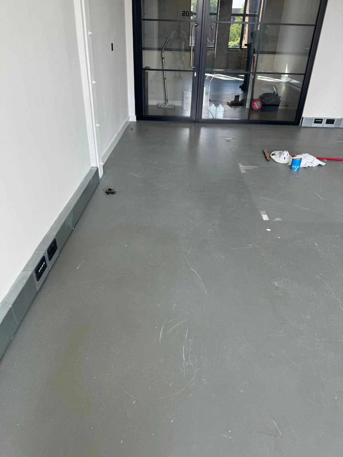 Resin floor in Hackney studio space showing surface scratches and preparation for deep cleaning and sealing.