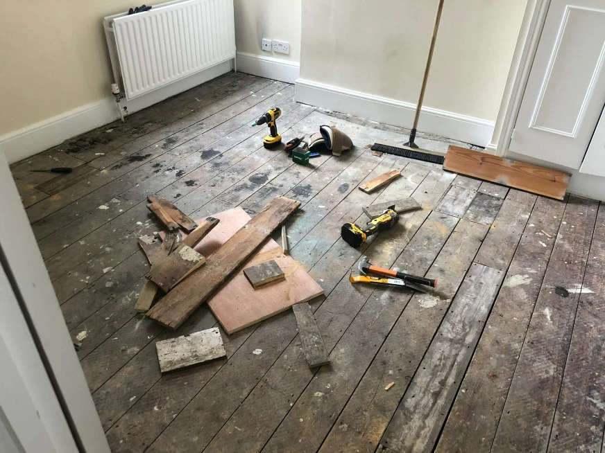 Damaged pine floorboards in a London hallway