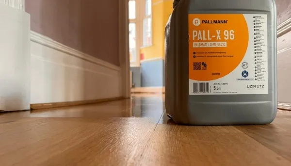 A newly lacquered oak floor in Wanstead, London, with a container of Pall-X 96 semi-gloss lacquer in the foreground.