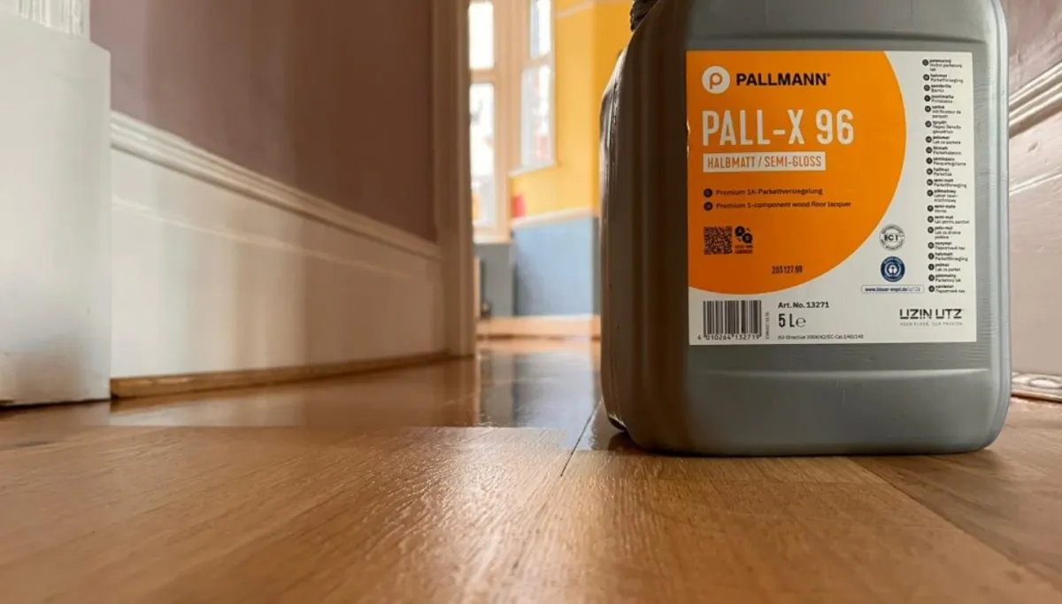 A newly lacquered oak floor in Wanstead, London, with a container of Pall-X 96 semi-gloss lacquer in the foreground.