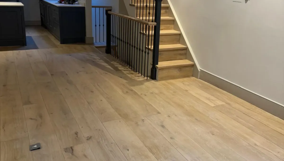 Oak flooring and stairs refinished with a subtle white finish in a Kensington home, showcasing seamless transitions and natural tones.