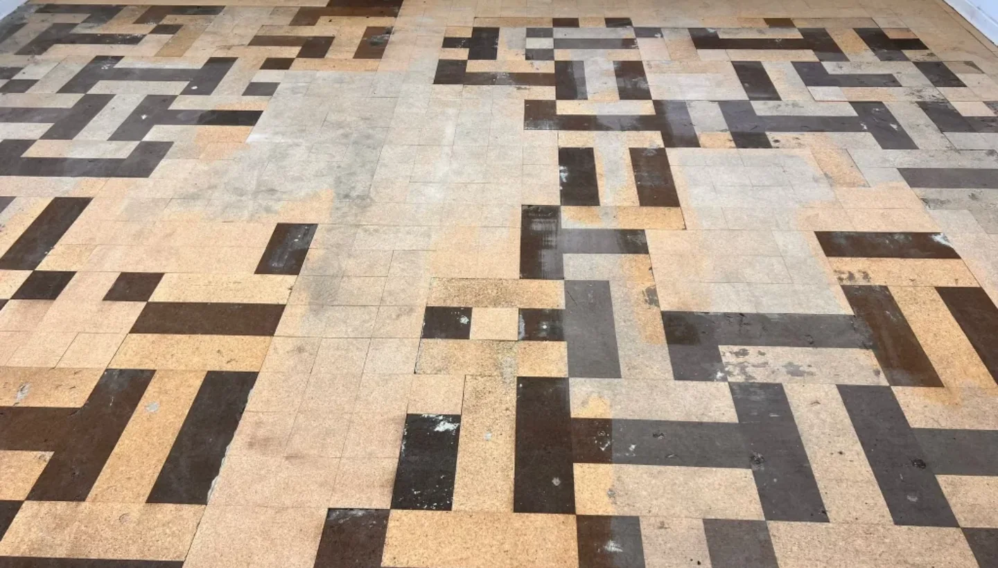 Partially restored cork floor in a London school, showing new tiles fitted and stained to match the original pattern.