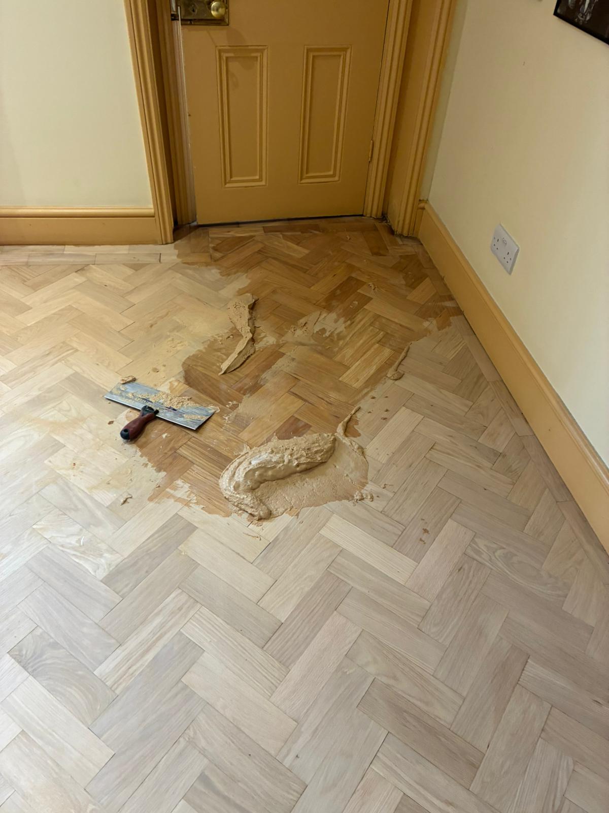 Oak parquet floor being filled and prepared before finishing in Angel, London