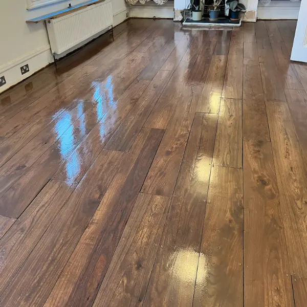 Sealed wooden floorboards with a rich stain and glossy finish in a London living room