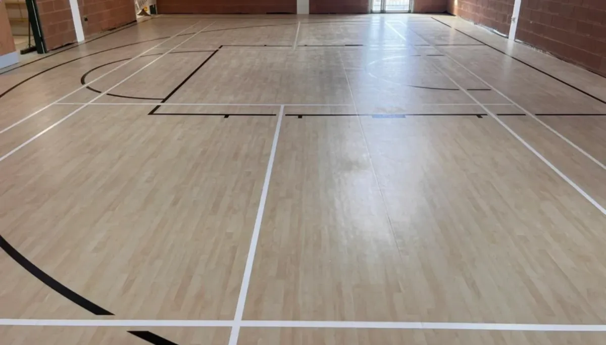 Newly finished sports hall floor in London with precise court markings and a protective PU sealer for durability and slip resistance.