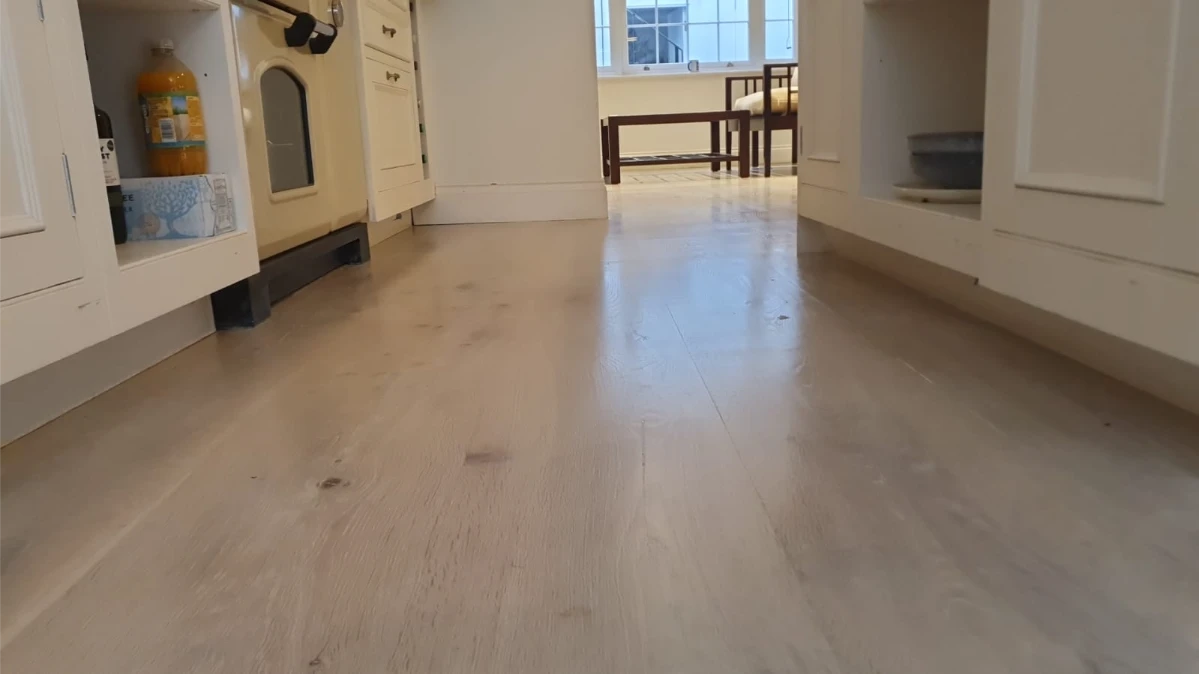Whitewashed wooden floor in a kitchen area with a Scandinavian-style finish, restored for durability and elegance in Angel, London.