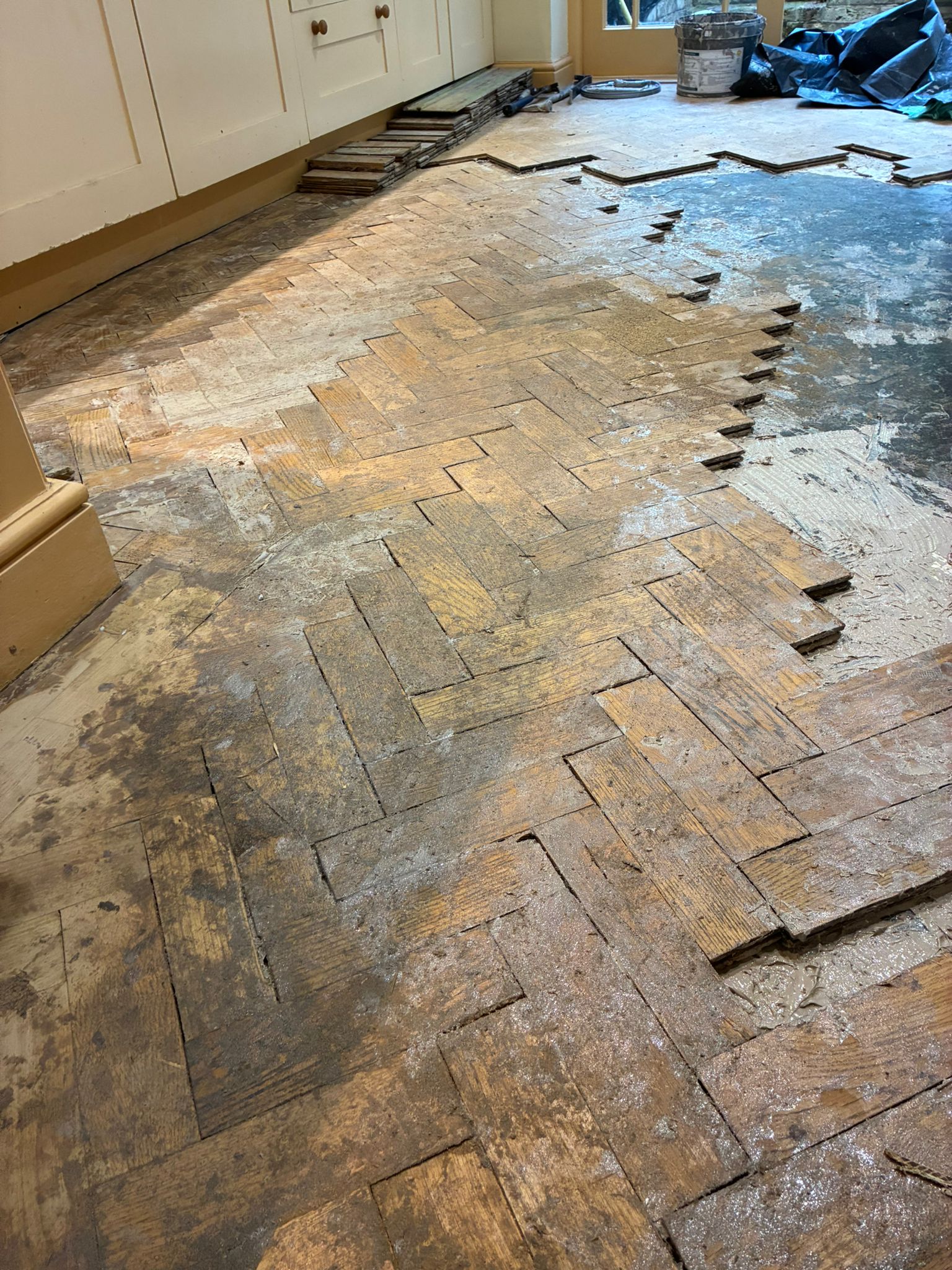 Damaged oak parquet being lifted in kitchen in Angel, London