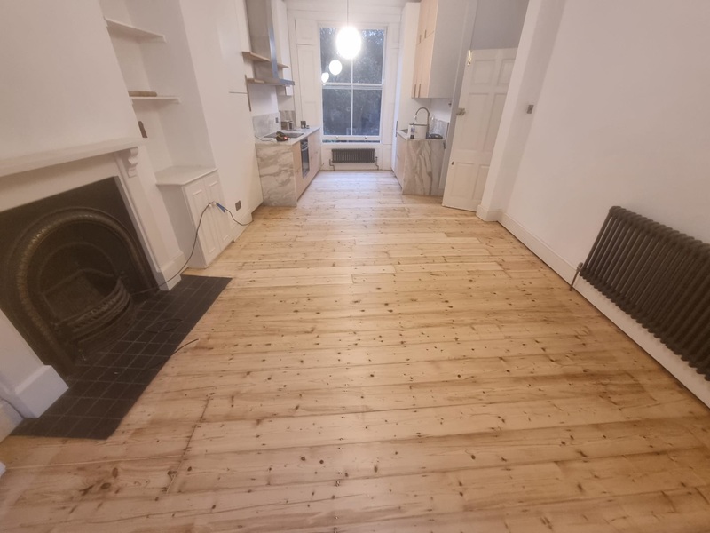 Wide view of restored Victorian pine floorboards in London home after sanding and finishing