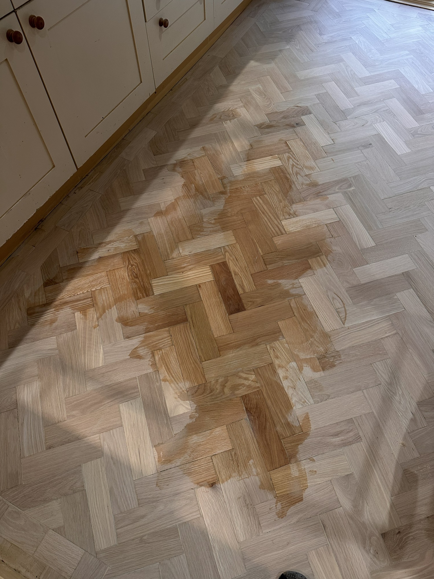 Oak parquet kitchen floor with colour test during sanding and restoration in Angel, London