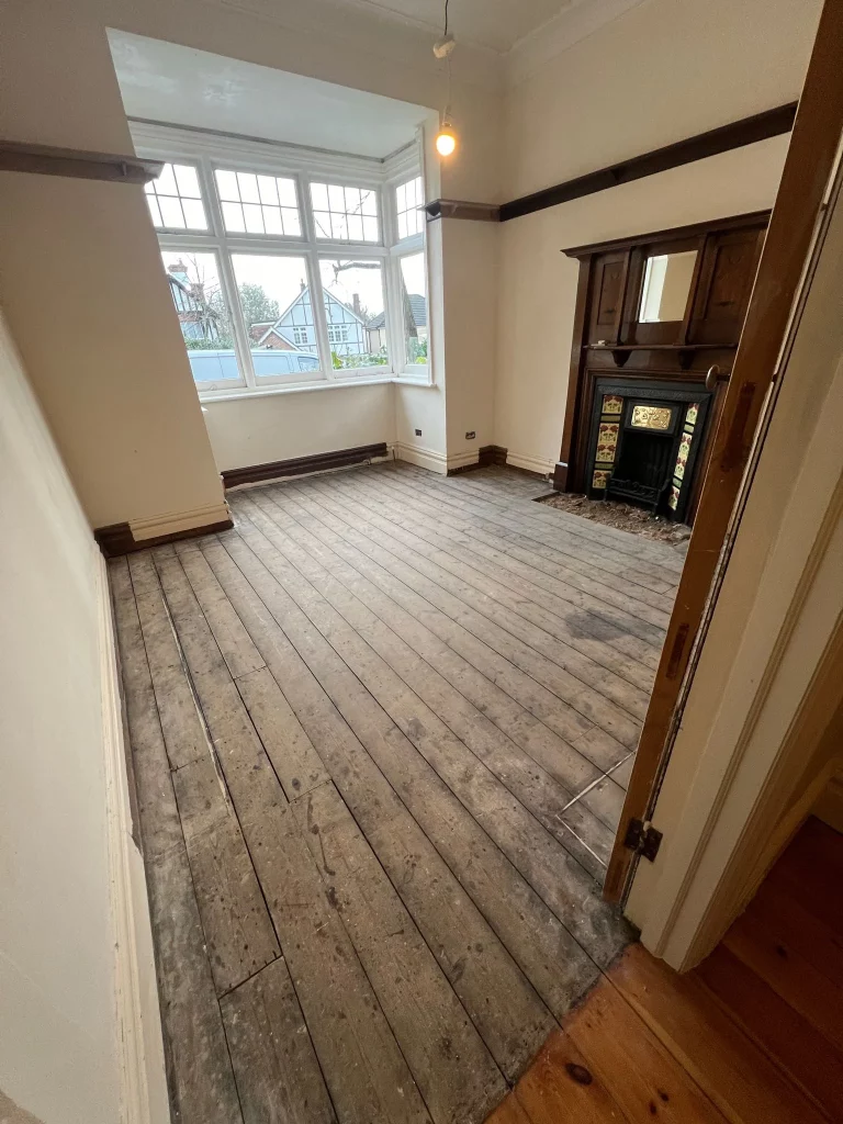 Aged pine floorboards in Woodford Green, London, before professional sanding and restoration.
