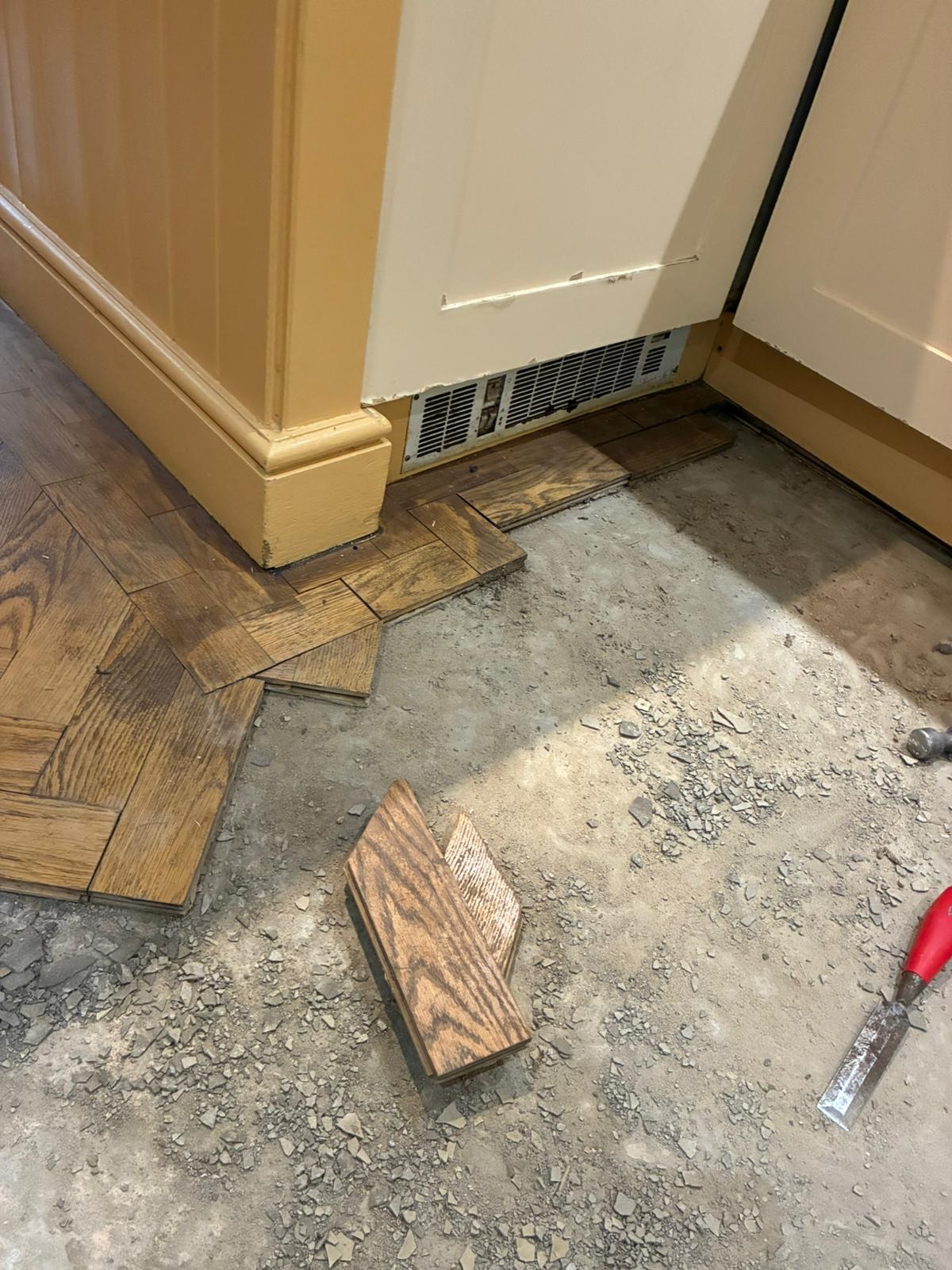 Parquet floor repair area in kitchen before reinstatement in Angel, London
