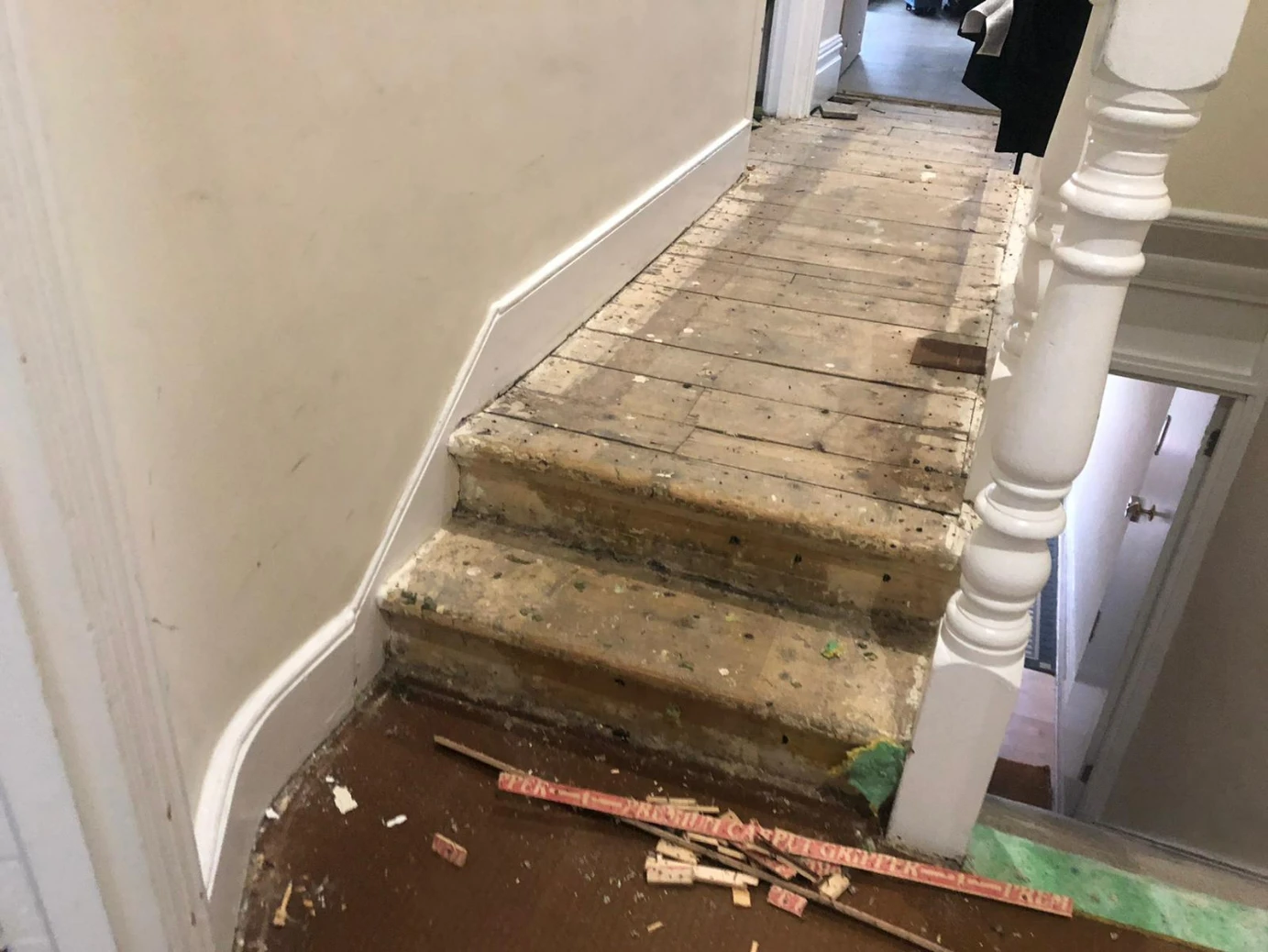 Damaged pine floorboards in a London hallway