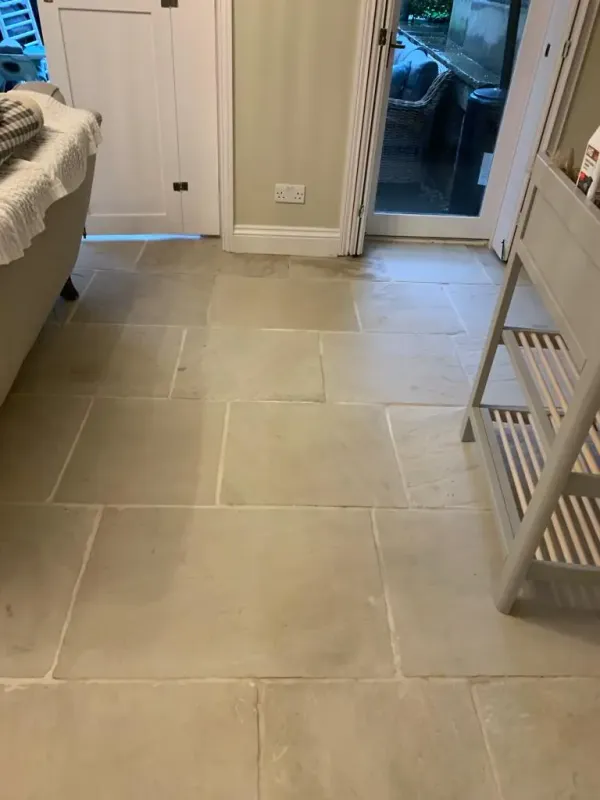 Light beige sandstone floor tiles in kitchen with glass door.