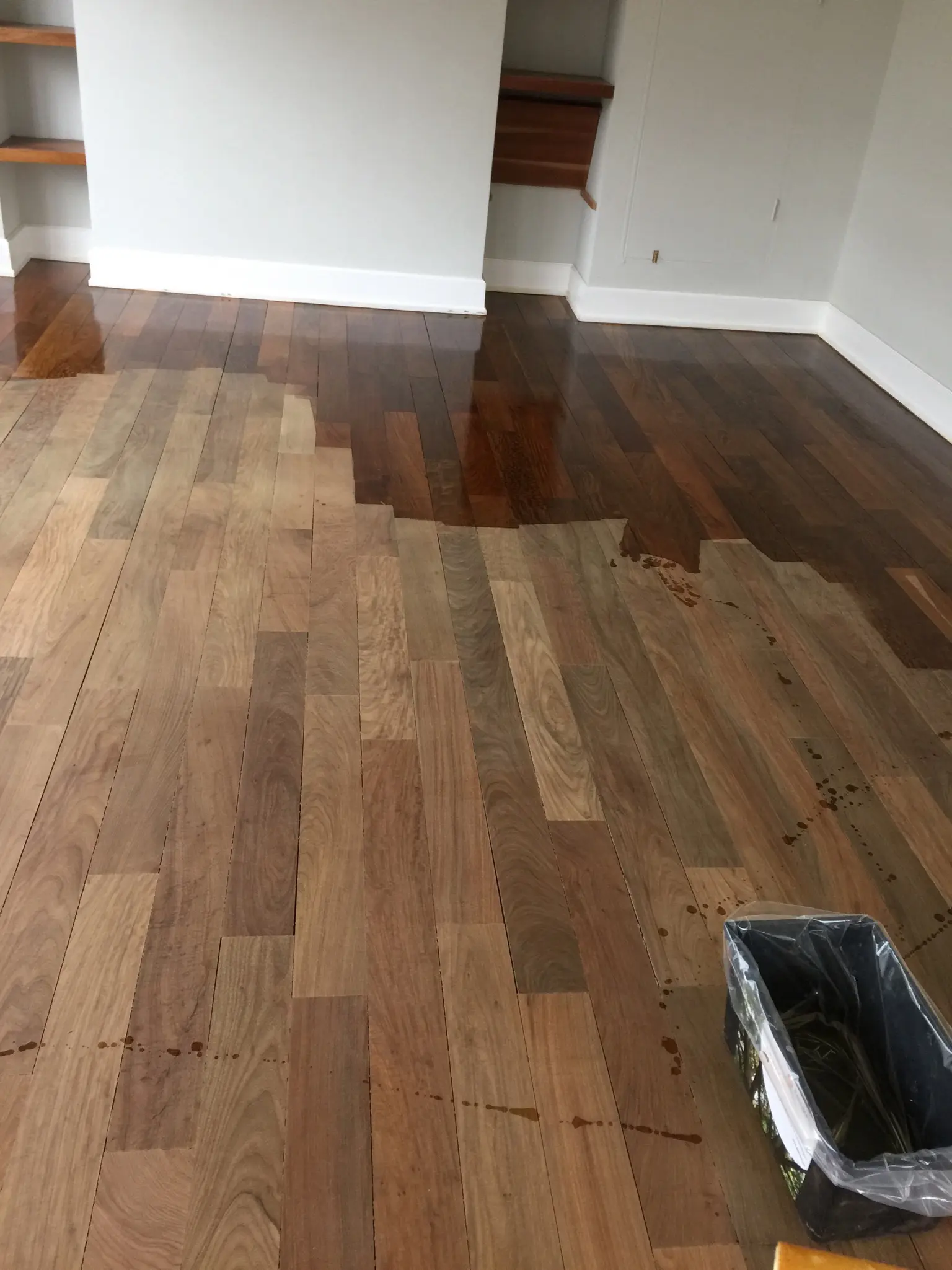 Application of Pallmann Allbase primer on an Ipe Lapacho wood floor in London, showcasing the difference between the untreated and primed sections of the wood.