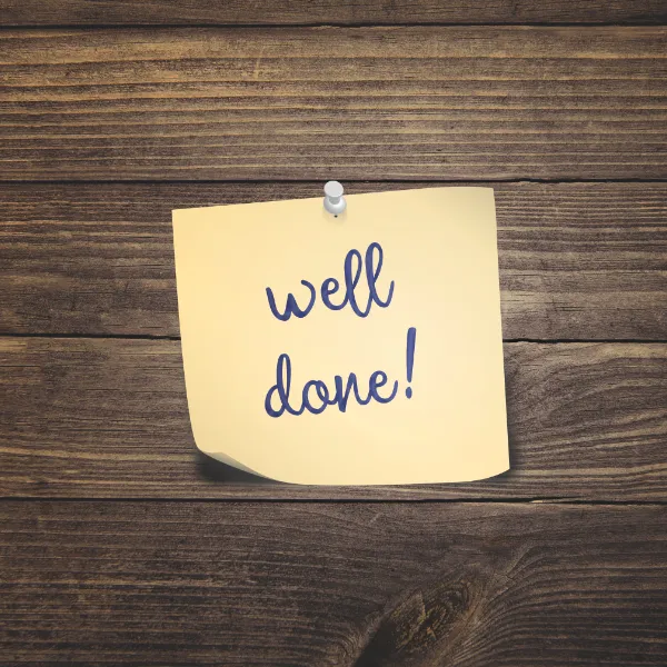 Sticky note with “Well done!” on wooden background symbolising satisfied floor sanding customers in Chelsea