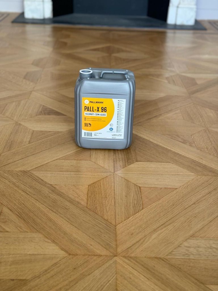 Container of Pallmann Pall-X 96 semi-gloss lacquer sitting on a freshly restored parquet floor.