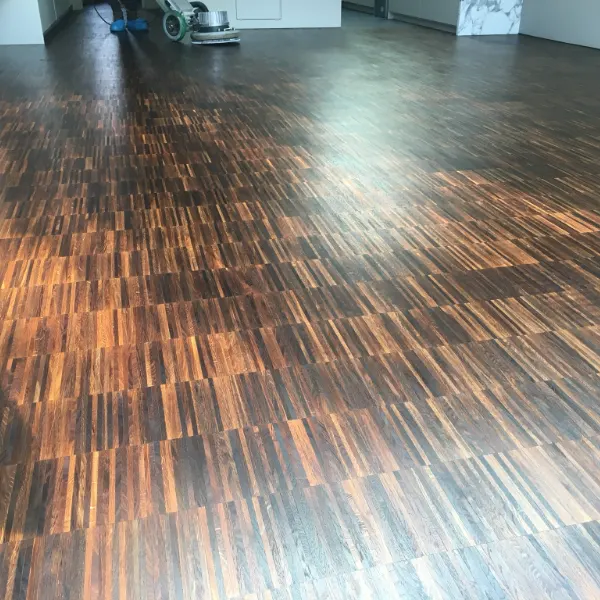 Wood floor in a London apartment during deep cleaning, lifting surface grime without sanding.