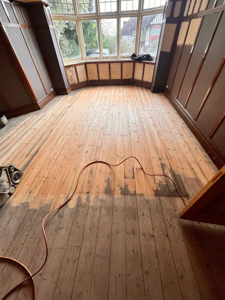 Pine floorboards in Woodford Green, London, during the sanding process.