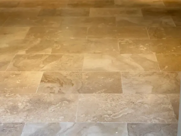 Clean limestone tile floor with natural stone variation and soft honed finish