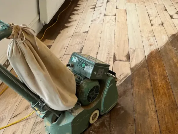 Professional floor sanding machine in action, showing dust-free sanding results on a wooden floor in London.