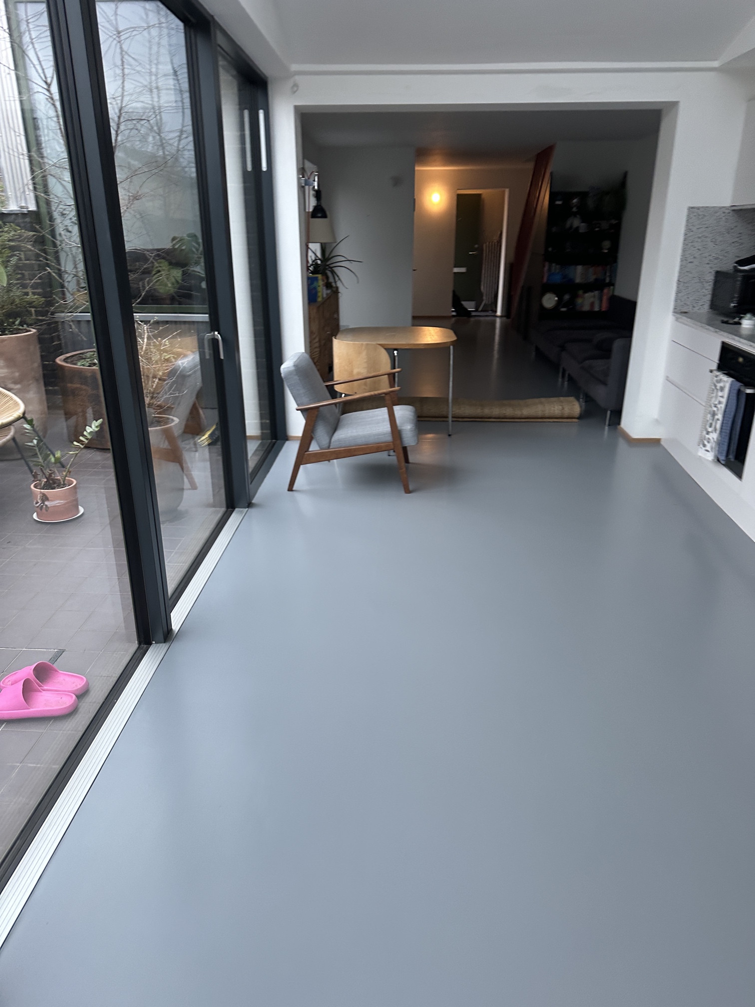 Open-plan room with restored grey floor after recolouring and sealing in Kennington South London