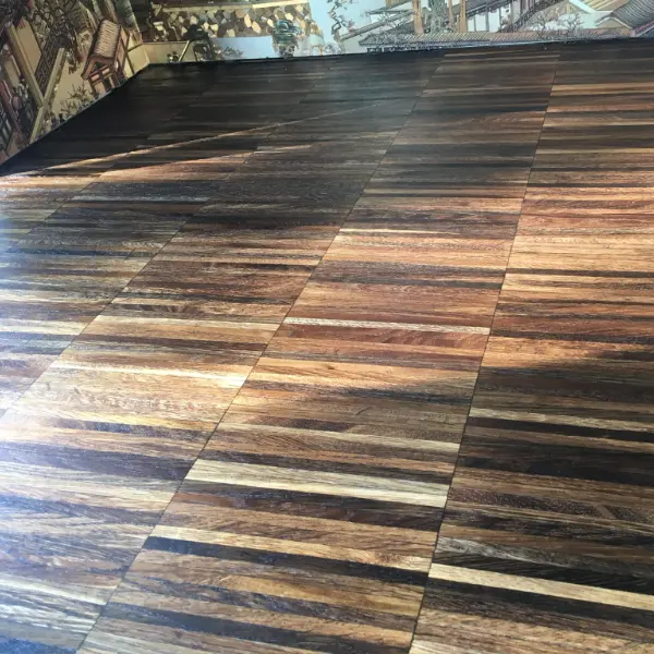 Detailed view of a block-patterned wooden floor after sanding and partial finishing in a Kensington property