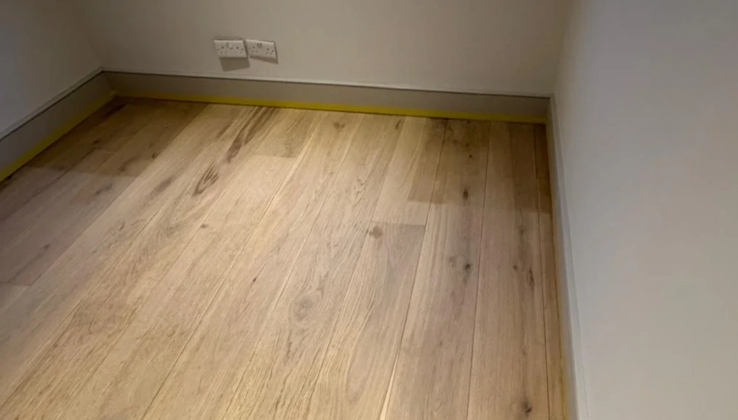 Restored oak floor in a Kensington home showing areas with uneven colour absorption due to natural wood variations.
